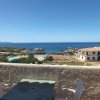 Vista sul mare da un balcone con tavolo e sedie.