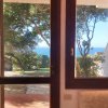 Vista mare da una finestra, alberi in giardino.