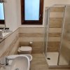 Bagno con doccia angolare e finestra.