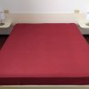 Letto matrimoniale con copriletto rosso.
