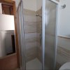 Bagno con box doccia e pareti piastrellate.