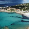 Spiaggia e mare turchese con colline.