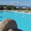 Ampia piscina con sdraio e ombrelloni.