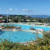 Piscine circondate da vegetazione e vista mare.