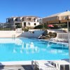 Piscina con ombrelloni e edificio sullo sfondo.