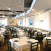 Ampia sala da pranzo con tavoli apparecchiati.