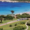 Panorama di una spiaggia con prato e trenino turistico.