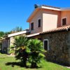 Edificio con pareti in pietra e giardino con palme.