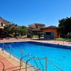 Piscina con case e giardino sullo sfondo.