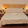 Letto matrimoniale con testiera decorata e due lampade.