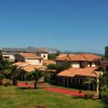 Complesso residenziale con giardini e palme.