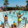 Persone che fanno acquagym in una piscina all'aperto con vista mare.