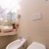 Bagno moderno con lavabo, bidet e decorazioni floreali.