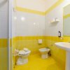 Bagno con piastrelle gialle, lavabo e bidet.