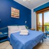 Camera blu con letto matrimoniale e balcone.