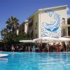 Una piscina con un edificio decorato da un murale di onde e delfini.