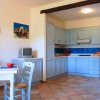 Cucina con mobili azzurri e piccolo tavolo apparecchiato.