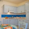 Cucina con mobili azzurri e piastrelle blu sul fondo.