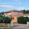 Casa rustica in pietra e intonaco rosa con giardino.