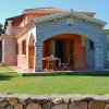 Casa con portico in pietra e giardino verde.