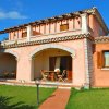 Casa mediterranea con veranda e giardino curato.