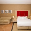 Camera con letto grande e divano beige.