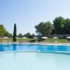 Ampia piscina con lettini e ombrelloni.