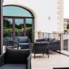 Terrazza esterna con sedie e divani neri.