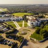 Veduta aerea di un grande complesso con parcheggi e aree verdi.