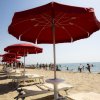 Ombrelloni rossi e sdraio su una spiaggia.