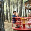 Bambini su una giostra in un bosco.