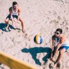 Due uomini giocano a beach volley sulla sabbia.