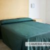 Camera da letto con copriletto verde.