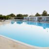 Ampia piscina con lettini bianchi intorno.