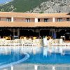 Complesso alberghiero con piscina e montagne sullo sfondo.