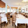 Ampia sala da pranzo con tavoli apparecchiati.