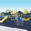 Parco giochi con scivoli gialli su pavimento morbido.