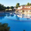 Ampia piscina con ponticello e edificio sullo sfondo.