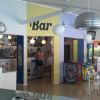Interno di un bar con tavoli e arredamento moderno.