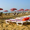 Lettini e ombrelloni colorati su una spiaggia.