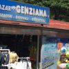 Esterno di un bazar con cartello e articoli esposti.