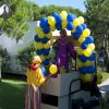 Veicolo decorato con palloncini blu e gialli in un parco.