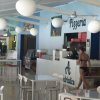 Interno di una pizzeria con tavoli e sedie.
