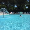 Una piscina con una fontana a cupola e lettini intorno.