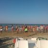 Gruppo di persone fa ginnastica sulla spiaggia.