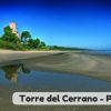 Spiaggia con torre e riflesso sull'acqua.