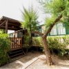 Esterno di una casa mobile con veranda e alberi.