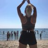 Figura femminile di spalle sulla spiaggia.