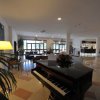 Interno di un hotel con pianoforte e sedie.