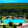 Una grande piscina con vista sul mare e alberi intorno.